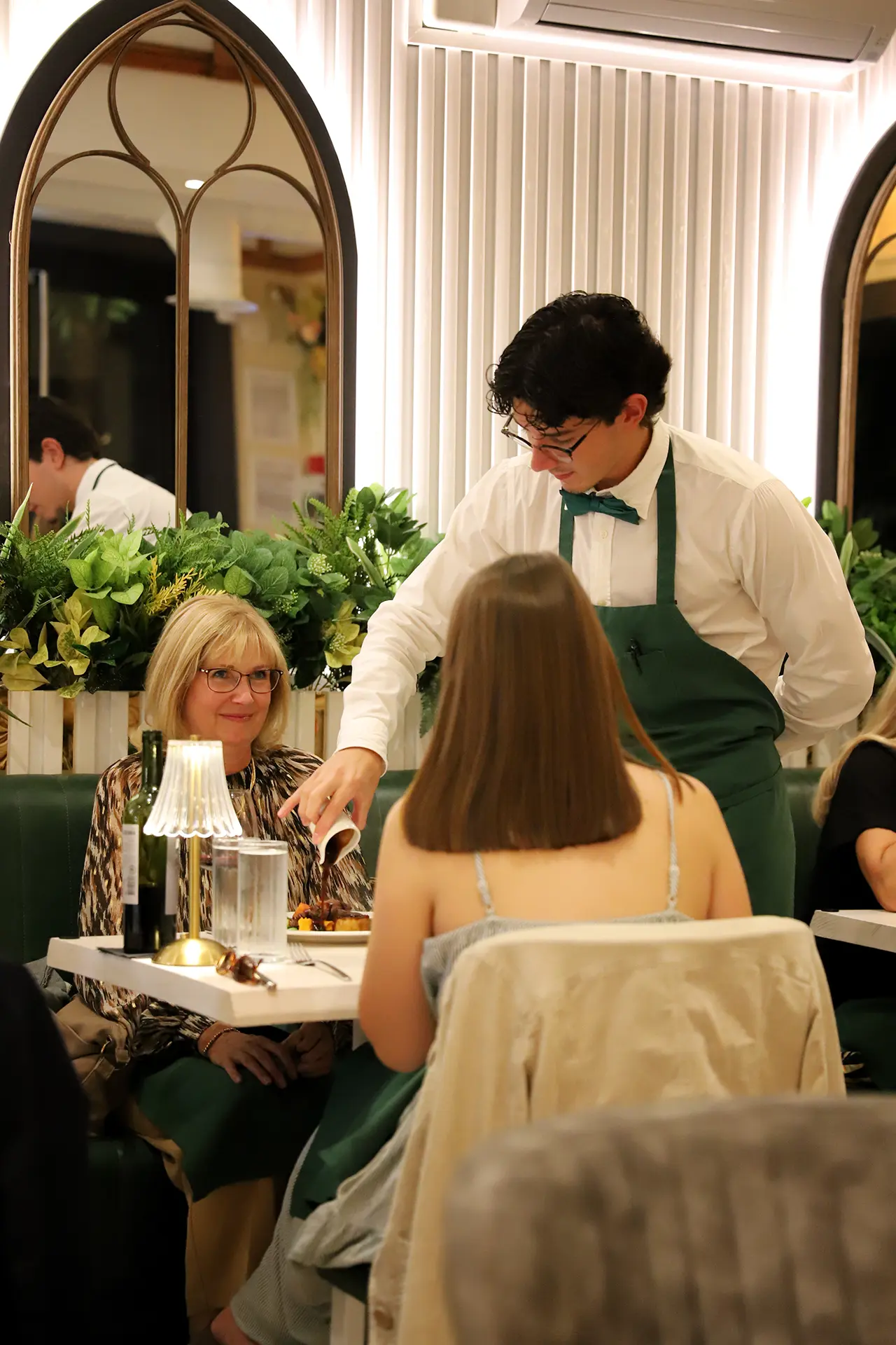 A waiter finishing a plate at the table